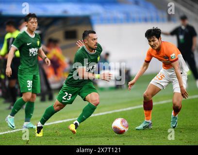 Qingdao, Chinas Provinz Shandong. Mai 2024. Li Ke (C) aus Peking Guoan bricht während des 13. Runde Spiels zwischen Qingdao Hainiu und Peking Guoan in der Chinesischen Super League 2024 in Qingdao, ostchinesischer Provinz Shandong, am 21. Mai 2024 durch. Quelle: Li Ziheng/Xinhua/Alamy Live News Stockfoto