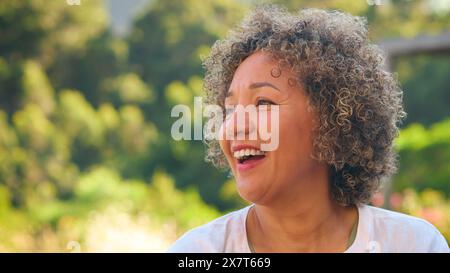 Porträt Der Lachenden Und Lächelnden Reichen Frau, Die Draußen Auf Dem Land Steht Stockfoto