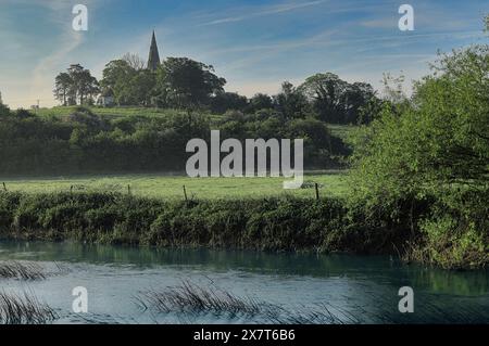 River Great Ouse fließt durch die Flusswiesen im Harrold-Odell Country Park, Befordshire, mit Kirchturm der Chellington Church in der Ferne Stockfoto