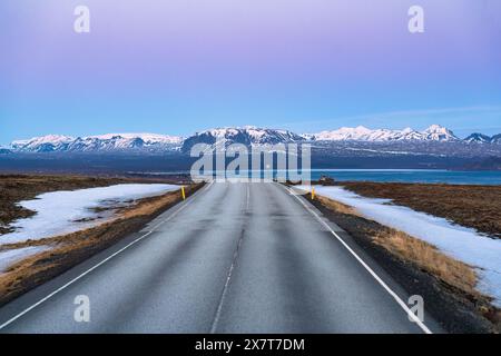 Roadtrip auf der Straße und schneebedeckte Bergkette in der Landschaft im Winter in Island Stockfoto