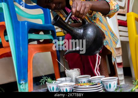 Frisch geröstete Kaffeebohnen, ein Mörtel und ein Pissel mit Jebena und Räucherrauch schaffen eine traditionelle äthiopische Kaffeezeremonie Stockfoto