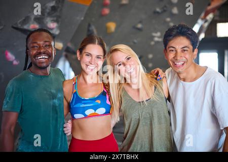 Porträt Von Kletterern Und Instruktoren, Die An Der Kletterwand Im Indoor Activity Centre Stehen Stockfoto