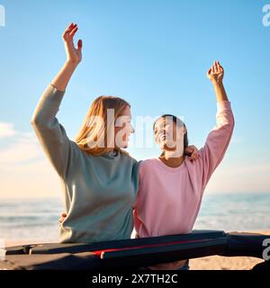 Zwei Frauen Im Urlaub Mit Dem Auto Fahren Auf Einem Roadtrip Abenteuer Zum Strand Stehend Durch Das Dach Stockfoto