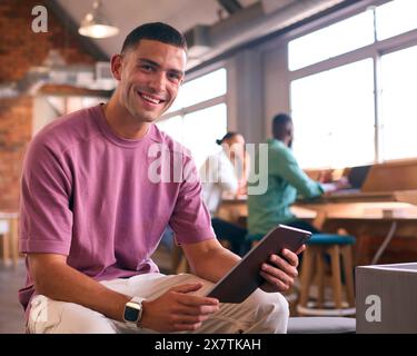 Porträt Eines Jungen Geschäftsmannes Mit Digitalem Tablet, Das In Modernen Großraumbüros Arbeitet Stockfoto