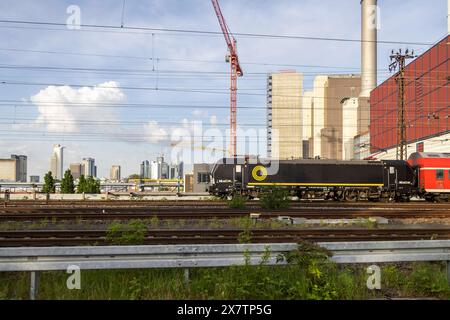 Regionalzug mit Lokomotive der Gesellschaft Beacon, Kraftwerk Mainova, Skyline von Frankfurt. // 30.04.2024: Frankfurt am Main, Hessen, Deutschland *** Regionalzug mit Leuchtenlokomotive, Mainova-Kraftwerk, Frankfurter Skyline 30 04 2024 Frankfurt am Main, Hessen, Deutschland Stockfoto