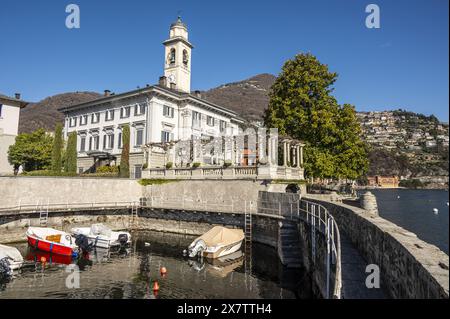 Wunderschöner kleiner Hafen in Cernobbio mit einer Kirche im Hintergrund Stockfoto