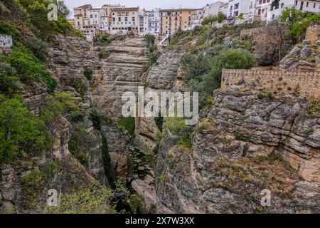 Der Fußweg und die Terrassen der Jardines de Cuenca entlang der Klippe des El Tajo de Ronda Canyon und des Guadalevin Flusses in Ronda, Provinz Malaga, Spanien. Die Brücke ragt 390 Meter über dem Fluss und dauerte von 1751 bis 1793. Stockfoto