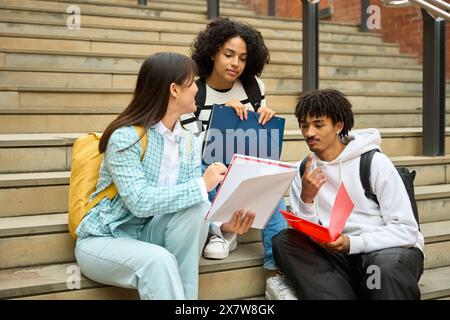 Drei junge Studenten teilen sich Notizen Stockfoto