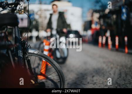 Urbanes Radfahren und aktiver Lebensstil: Ein Fahrrad im Fokus mit verschwommener Stadtkulisse Stockfoto