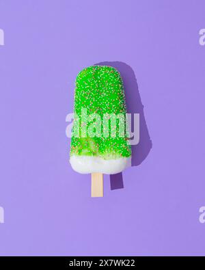 Grün glasiertes Eis-Eis-Eis auf hellviolettem Hintergrund. Minimales Sommerkonzept. Eisästhetik. Flache Lagen. Stockfoto
