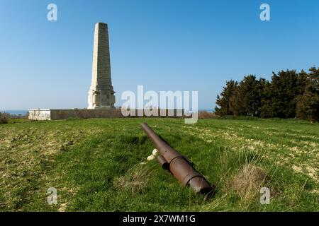 Canakkale, Türkei - 18. März 2024: Kanone aus dem Ersten Weltkrieg auf grünem Gras mit Cape Helles Memorial im Hintergrund, gewidmet über 20.000 britischen Soldi Stockfoto