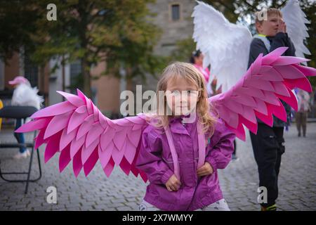 Schönes Mädchen mit rosafarbenen Engelsflügeln. Kleines süßes Mädchen in rosa Jacke und rosa handgefertigten Flügeln. Stockfoto