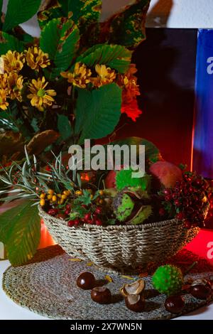 Eine schöne Komposition aus Kastanien, Herbstblumen und Blättern, Sanddorn und Weißdornbeeren. Herbststillleben, Herbststrauß in einem Weidenbock Stockfoto