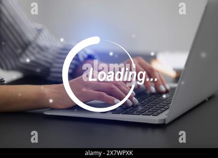 Wird Geladen. Frau, die drinnen am Laptop arbeitet, Nahaufnahme Stockfoto