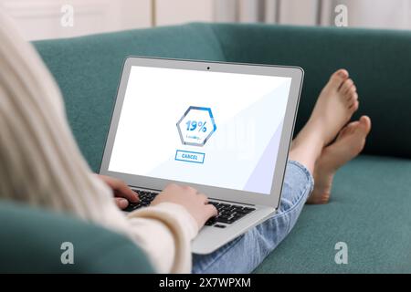 Bildschirm wird geladen, der den Fortschritt anzeigt. Frau, die drinnen an einem Laptop arbeitet, Nahaufnahme Stockfoto