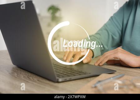 Wird Geladen. Frau, die drinnen am Laptop arbeitet, Nahaufnahme Stockfoto