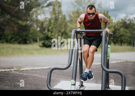 Fitness-Enthusiasten, die in einem üppigen urbanen Park in den Bars im Freien tauchen Stockfoto