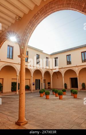 Der Innenhof des ehemaligen Convento de Santo Domingo mit Bogengängen in Ronda, Provinz Malaga, Spanien. Die ehemalige Kirche und das Kloster wurden zu einem Ausstellungsraum und Kunstzentrum restauriert. Stockfoto