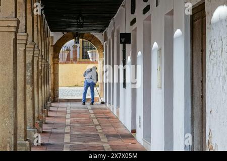 Ein Ladenbesitzer durchstreift die bogenförmige Arkade im Arcos Antiguo Claustro Santo Domingo in Ronda, Provinz Malaga, Spanien. Stockfoto