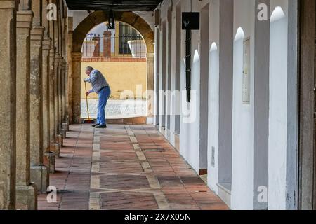 Ein Ladenbesitzer durchstreift die bogenförmige Arkade im Arcos Antiguo Claustro Santo Domingo in Ronda, Provinz Malaga, Spanien. Stockfoto