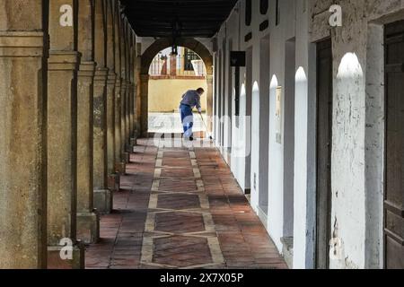 Ein Ladenbesitzer durchstreift die bogenförmige Arkade im Arcos Antiguo Claustro Santo Domingo in Ronda, Provinz Malaga, Spanien. Stockfoto