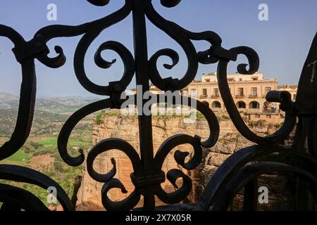 Das Hotel Parador de Ronda ist durch einen schmiedeeisernen Grill auf der Neuen Brücke in Ronda, Provinz Malaga, Spanien, zu sehen. Stockfoto