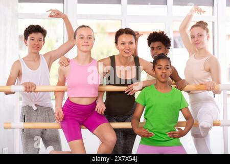 Ballettlehrerin posiert mit einer Gruppe Teenager in der Barre Stockfoto