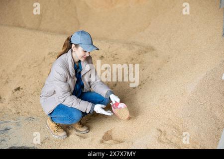 Bäuerin hockt auf einem Haufen Sojabohnenschalen Stockfoto