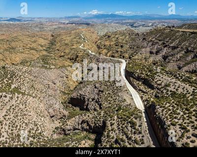 Lange, kurvige Straße führt durch zerklüftete Hügellandschaften mit zerklüfteten Felsformationen, aus der Vogelperspektive, Gorafe-Wüste, Granada, Andalusien, Spanien, Europa Stockfoto