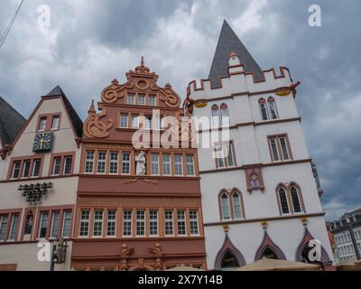 Zwei gotische Gebäude mit detaillierten Fassaden unter bewölktem Himmel, historische Hausfronten mit einem Denkmal vor einem bewölkten Himmel, Trier, Deutschland, Europa Stockfoto