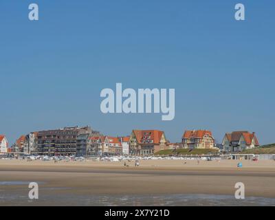 Häuser und Gebäude säumen den Strand an einem klaren Sommertag, breiter Sandstrand am Meer mit Möwen und ein Stadtpanorama auf der Promenade, de haan, BE Stockfoto