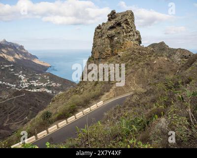 Die Straße windet sich um eine hohe Klippe in einer bergigen Landschaft mit Meerblick, Bergen und Tälern auf einer Insel im atlantik mit Palmen und Berg Stockfoto