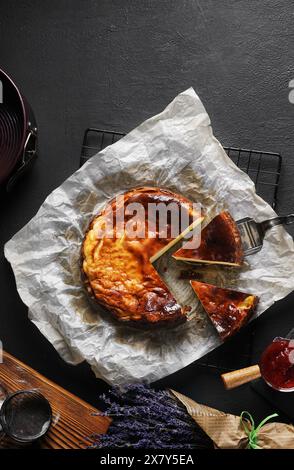 Blick von oben auf den baskischen Käsekuchen mit Marmelade auf schwarzem Tisch. Kopierbereich Stockfoto