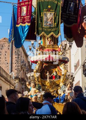 Feier mit einer kunstvollen Statue mit Fahnen und religiösen Symbolen, besucht von Menschen in einer Straße, Catania, italien, 3. Februar 2024, 3. Tag f Stockfoto