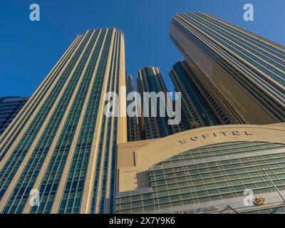 Komplex aus modernen Wolkenkratzern kombiniert mit einem Sofitel-Gebäude unter klarem Himmel, modernen Wolkenkratzern mit Glasfassaden und vielen Fenstern, Abu Stockfoto