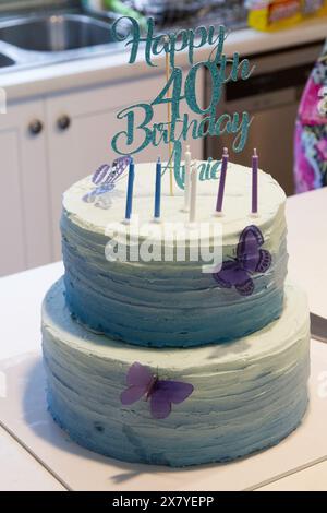 40. Geburtstagstorte, 2 Ebenen in blau und weiß Zuckerguss mit Kerzen auf der Oberseite Stockfoto