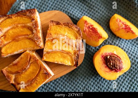 Ein Dessert aus geschnittenen Pfirsichen ist auf einem hölzernen Schneidebrett. Das Dessert ist mit Zucker bedeckt und sieht köstlich aus. Stockfoto