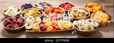 Schüsseln mit verschiedenen getrockneten Früchten auf Holztisch Stockfoto