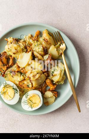 Köstliche herzhafte Abendessen oder Mittagessen, gebratene junge Kartoffeln mit Waldpilzen Chanterelles mit Dill, gekochte Eier, saisonale Speisen Stockfoto