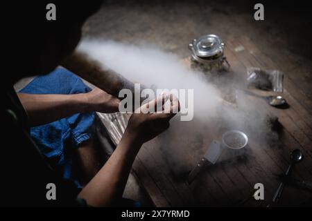 Ein Mann bereitet Marihuana auf einem Schneidebrett zu rauchen, Person, die Drogen raucht, Drogensüchtig, Drogensucht und Entzugssymptome Konzept. DrugsInte Stockfoto