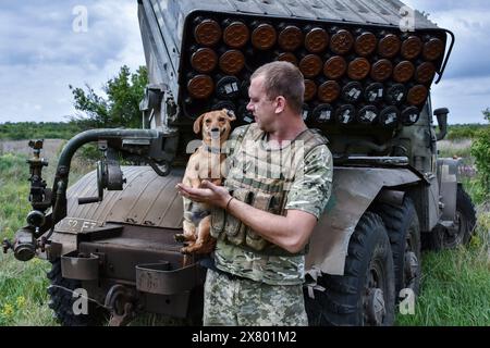 Orichhiv, Ukraine. Mai 2024. Ein ukrainischer Soldat der 65. Separaten Mechanisierten Brigade steht mit einem Hund beim Raketenwerfer BM-21 „Grad“ in der Nähe der Frontlinie in der Region Zaporischzhia. Die USA wollen "grundsätzlich", dass die Ukraine den Krieg gegen Russland gewinnt, sagte Matthew Miller, Sprecher des US-Außenministeriums, während eines Briefings. Miller wiederholte auch die Erklärung des US-Außenministers Antony Blinken, in der er über die strategische Niederlage sprach, die Russland "sich selbst gebracht hat", indem er den Krieg eingeleitet hat. Quelle: SOPA Images Limited/Alamy Live News Stockfoto