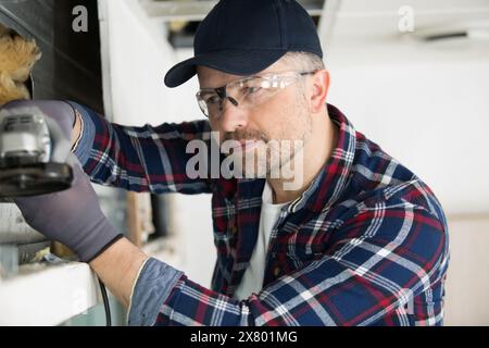 Ein Bauherr mit Winkelschleifer Stockfoto