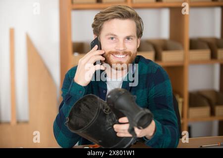 Lächelnder Automechaniker am Telefon Stockfoto