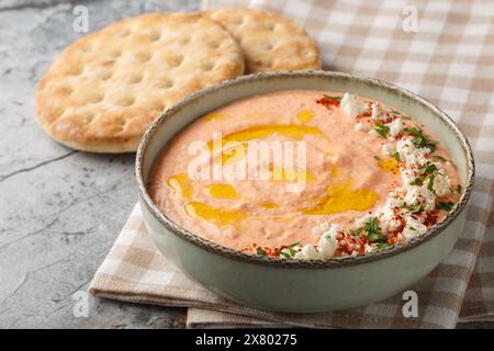 Griechischer TirokAfteri Aufstrich ist ein würziger Feta-Dip mit Fetakäse, gebratenen roten Paprika, Knoblauch und Chili in der Nähe auf der Schüssel auf dem Tisch. Horizontal Stockfoto