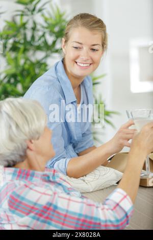 Lächelnde Mutter und Tochter, die mit Gläsern tosten Stockfoto