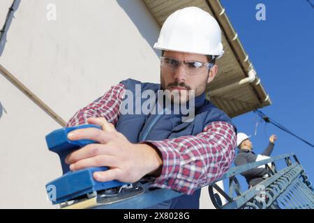 Junger Mann, der Schrauben auf einem Geländer festzieht Stockfoto