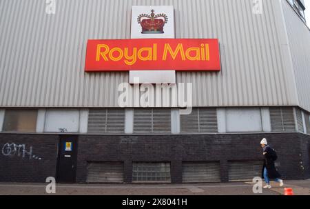 London, Großbritannien. Januar 2024. Eine Frau läuft am NW1-Zustellbüro in Camden vorbei, da die britische Regulierungsbehörde Ofcom vorschlägt, dass Royal Mail die Lieferungen auf drei Tage pro Woche reduziert. Quelle: Vuk Valcic/Alamy Stockfoto