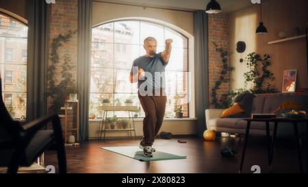 Starker Athletic Fit Mann mittleren Alters, der während des morgendlichen Workouts zu Hause in Sunny Apartment Cardio High Knie und Core Kräftigung Übungen macht. Fitness- und Erholungskonzept. Stockfoto