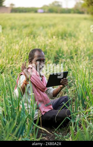 Indischer Landwirt, der Tablette hält Stockfoto