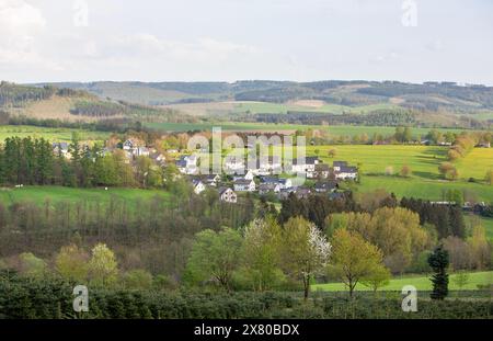 Weiße Häuser im Dorf bei schmallenberg im Frühjahr und die umliegende Landschaft des Sauerlandes in Deutschland Stockfoto